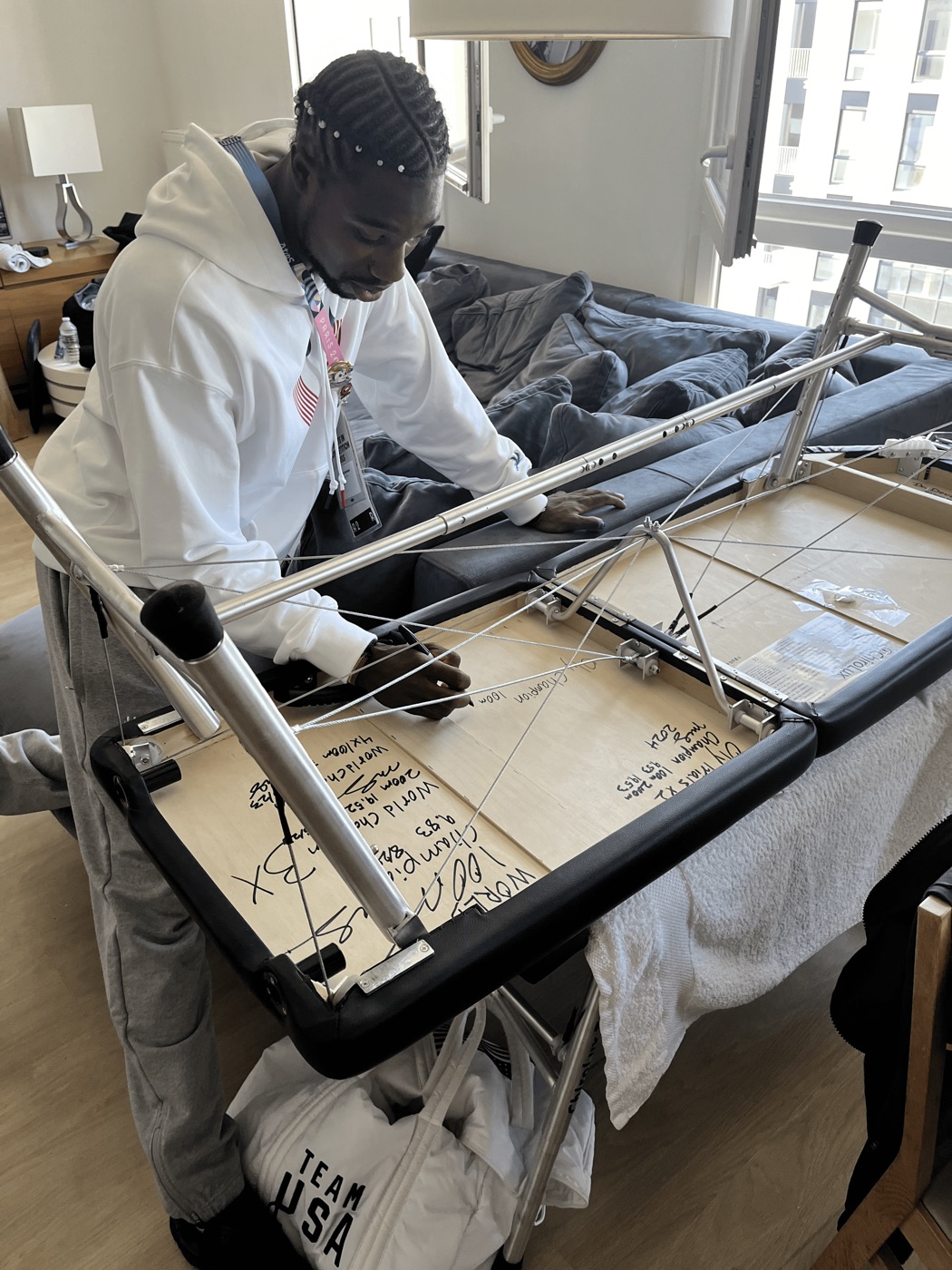 Noah Lyles signing the bottom of Dr. Obetz's adjusting table in Paris